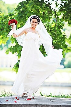 bride in white dress on background of green trees