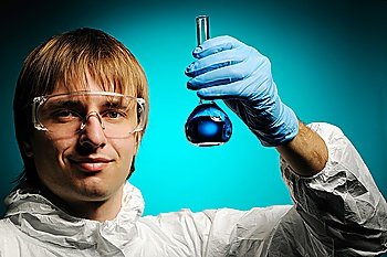 Scientist in protective wear and glasses showing flask with reagent