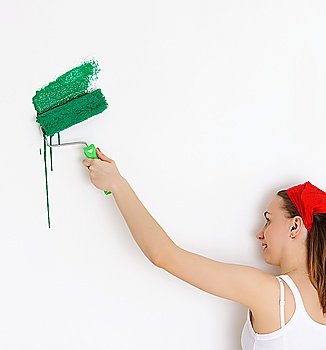Woman painting interior wall of home with paint roller