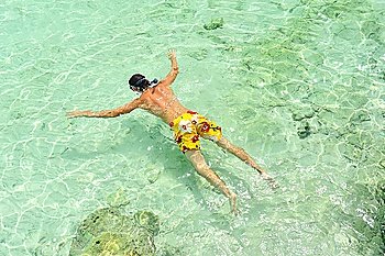 Man snorkeling at rocky beach