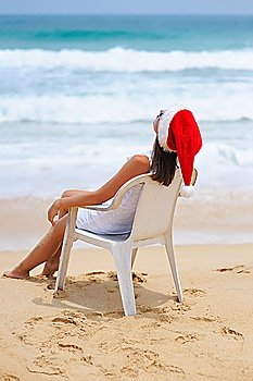 Woman on the beach in santa´s hat