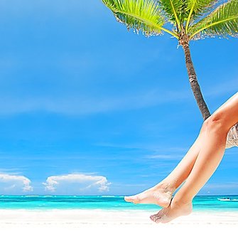 Woman on palm on caribbean beach