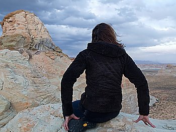 Woman leaning on rock looking at a view, Utah, USA