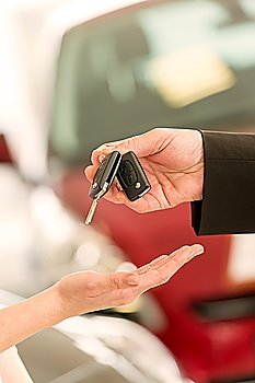Closeup of woman´s hand receiving car keys from agent