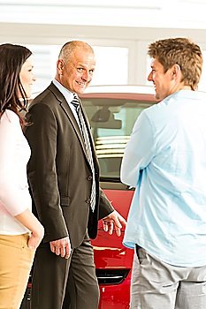 Portrait of car dealer talking with customers