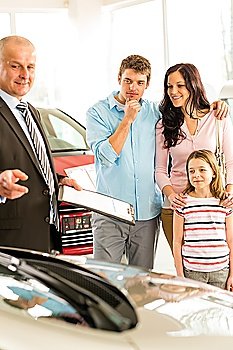 Salesman offering a family car to young couple