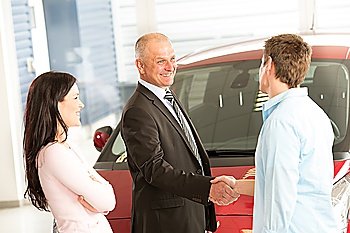 Caucasian couple purchasing a car in showroom