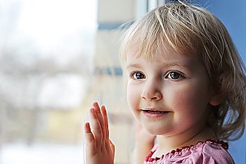 Beautiful  little girl is by window portrait