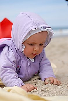 child lies on sea sand