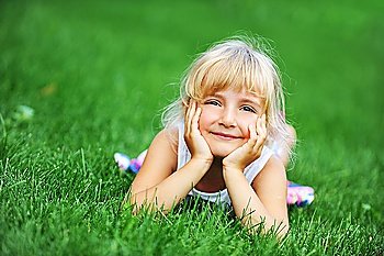 little girl relaxing on green grass