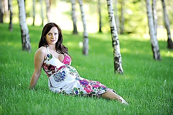 beautiful  woman  sitting on  grass in  birch grove . summer´s day.