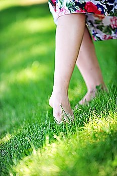 woman´s feet walking barefoot on  grass.  summer´s day