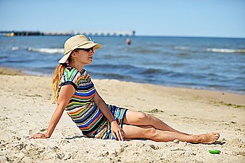 Happy young woman in straw hat on beach
