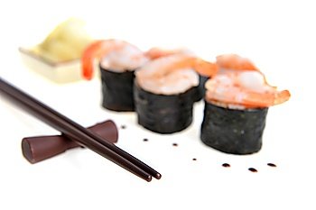 fresh sushi rolls and drop of sauce on  table