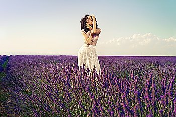Pretty glamorous lady standing in a field of lavender flowers