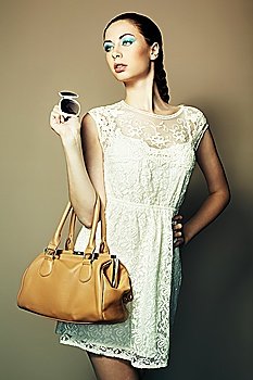 Portrait of beautiful young woman with a leather bag. Fashion photo