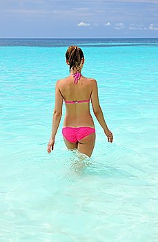 Woman at beach walking into water