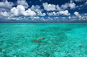 Man snorkeling in crystal clear turquoise water at tropical beach