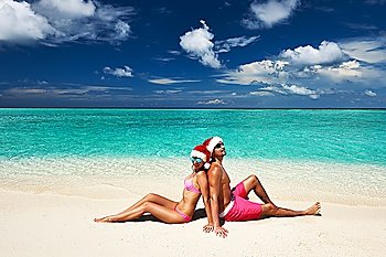 Couple in santa´s hat on a tropical beach at Maldives