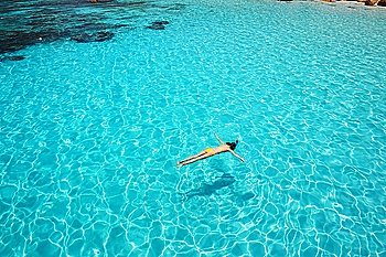 Woman snorkeling in crystal clear turquoise water at tropical beach