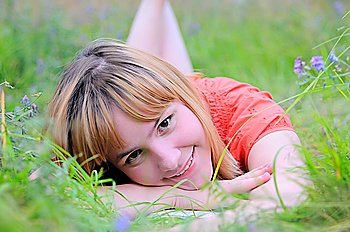 Young smiling woman lying on meadow