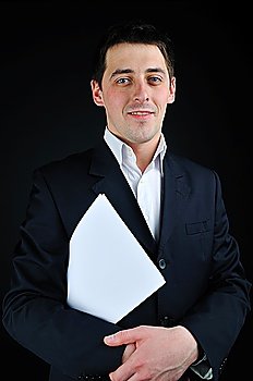 young man in suit with blank paper over dark background