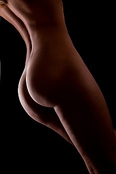 Beautiful ass of young woman over dark background