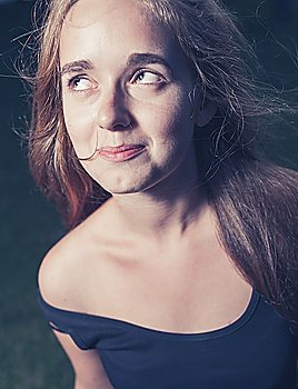 toned image of happy 20s young female outdoors in evening. Very close up shot.