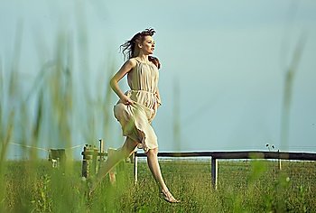 Delicate lady running on the green meadow