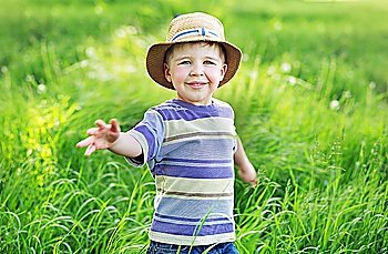 Portrait of a cute small kid playing  on the meadow