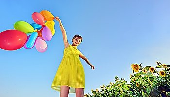 girl playing with balloons in summer time