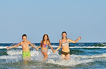kids  playing  in water against the waves