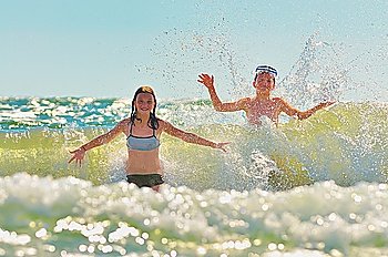 kids  playing  in water against the waves