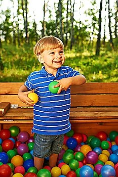 Happy child playing at colorful plastic balls playground high view