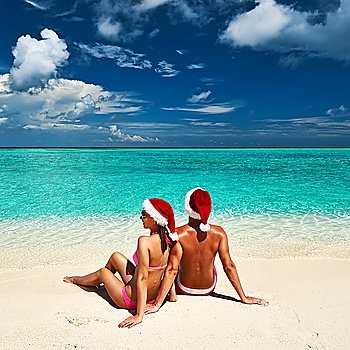 Couple in santa´s hat on a tropical beach at Maldives