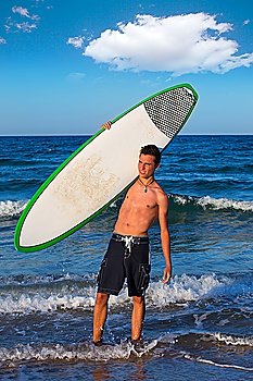 Boy handsome teen surfer holding surfboard in the blue beach