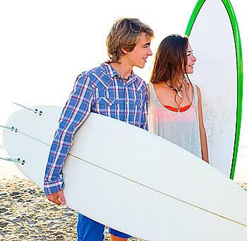 Teen surfer couple on beach shore with surfboards high key