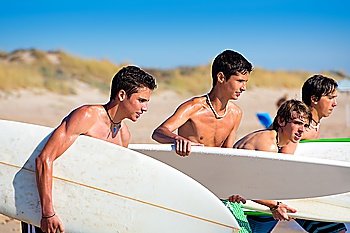 Surfer teen boys talking on beach shore holding surfboards