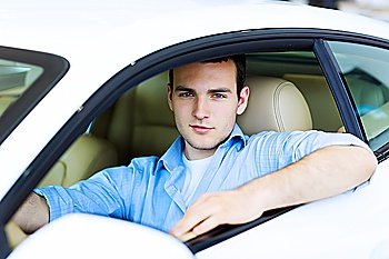 Young man sitting in car