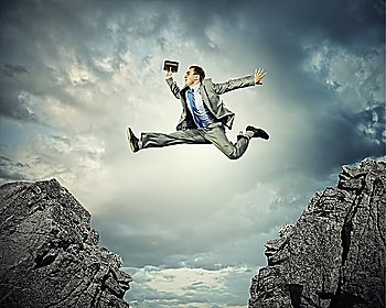 Businessman jumping over gap