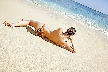 Young woman enjoying sunbath on the beach