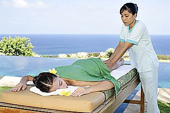 Womon lying on massage table outdoors