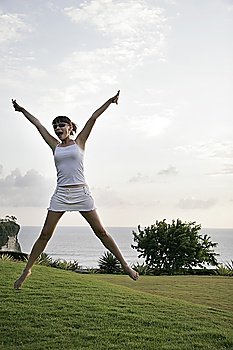 Young woman jumping spreadeagled