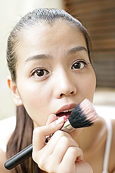 Young woman making up