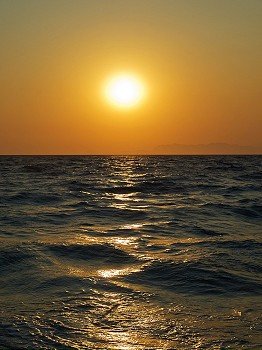 Aegean sea sunset with sun track on water surface. Rhodes island. Greece.