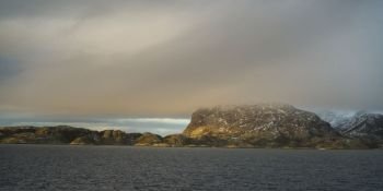 View of sea and mountain against cloudy sky, Nordland, Norway