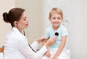 Happy little boy at the doctor, cute young pediatrician using stethoscope listening babys lungs, enjoying visit to doctor