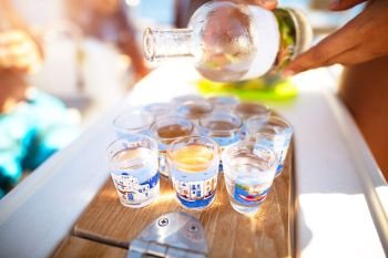 Party on the beach, refill glass with alcoholic beverage, drinking shots with friends, enjoying freedom, happy carefree summer vacation
. Party on the beach