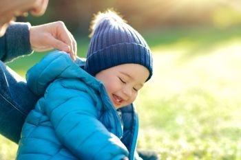 Cute little boy with his father playing outdoors on the fresh green grass field in bright sunny day, happy family with pleasure spending time together, enjoying first spring day. Happy family outdoors