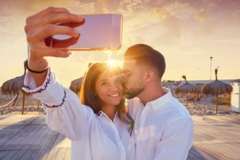 Couple young selfie photo in beach together vacation sunrise at Spain
